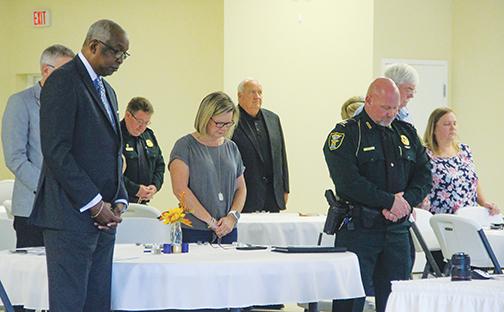 Members of clergy bow their heads in prayer Monday evening during a Faith & Blue event with the Putnam County Sheriff’s Office.