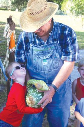 Farmer Bob, aka Bob Reed, gets a hug from Lillian Cone, 4, following a tour of the Pumpkin Patch and storytime at Trinity United Methodist Church in Palatka on Thursday.