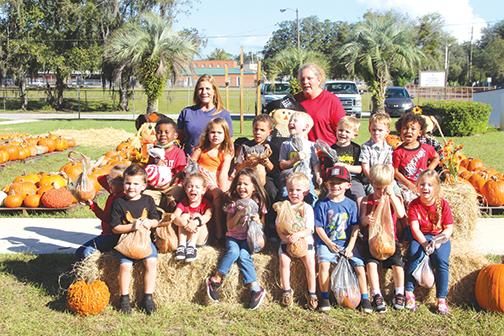 Pre-k students from Round Lake Academy are pictured with their teachers, Amy Hare, right, and Dixie Burkes, left, during a field trip Thursday to the Pumpkin Patch in Palatka.