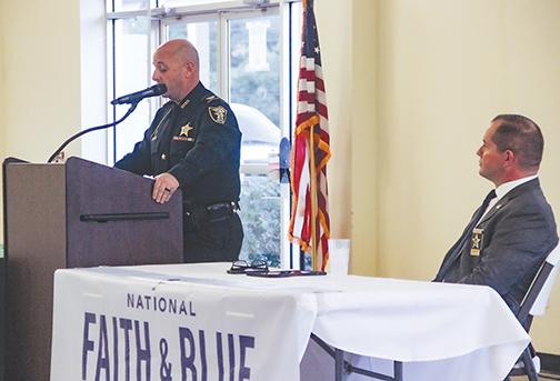 As Sheriff Gator DeLoach looks on, Putnam County Sheriff’s Office Col. Joe Wells speaks to religious leaders last week about body cameras coming to the agency.