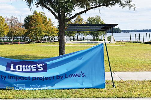 A Lowe’s banner is draped in front of the site where a new amphitheater is being constructed along the Palaka riverfront.