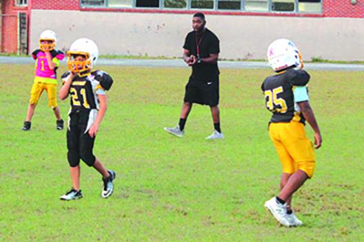 Palatka Panthers 10-and-under Pop Warner head coach Brandon Teel tells players what they did right and wrong during a play in practice on Thursday. (MARK BLUMENTHAL / Palatka Daily News)