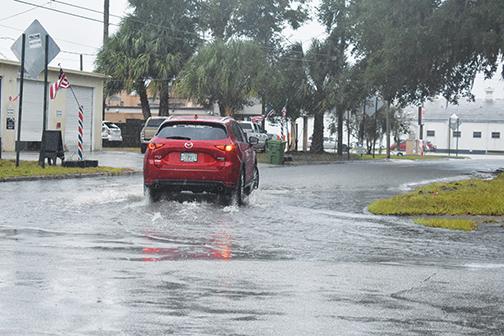 A sports utility vehicle traverses through floodwaters at the corner of St. Johns Avenue and 14th Street in Palatka as rain continues to fall Friday afternoon.
