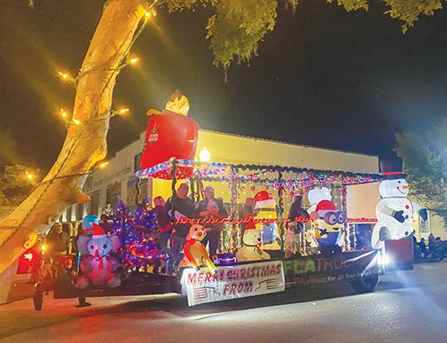 People representing FLA Trucking & Paving get into the holiday spirit Friday as they ride down St. Johns Avenue during the Palatka Christmas Parade, which returned this year after being canceled in 2020 because of COVID.