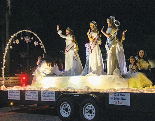 Putnam County pageant queens wave to jubilant parade-goers Friday evening. 