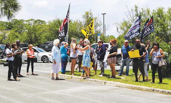 Protesters in favor of and against removing the Confederate monument from the Putnam County Courthouse lawn argue outside the Board of County Commissioners chamber in July.