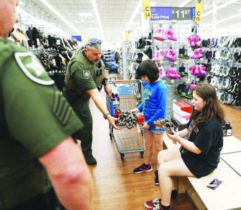 Putnam County Sheriff’s Office deputies help local children and teens pick out Christmas toys Monday at Walmart in Palatka. Allison Waters-Merritt/Putnam County Sheriff's Office