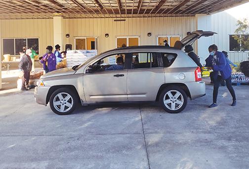 A volunteer loads food into a vehicle at the Family Life Center.