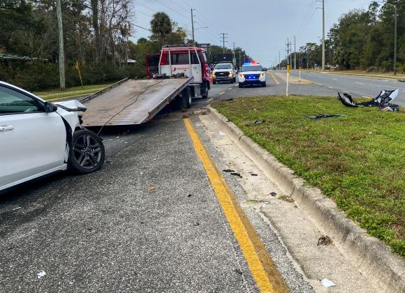 Photo by Sarah Cavacini/Palatka Daily News. A Johnson's Towing and Recovery works to start taking a white vehicle away from a crash involving the damaged car and a Putnam County School District bus early Tuesday morning.