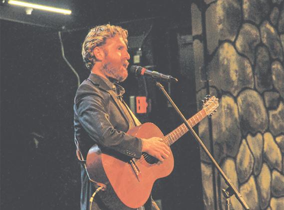 Author Sean Dietrich tells a childhood story before playing a tune on his acoustic guitar Thursday at the Florida School of the Arts in Palatka. 