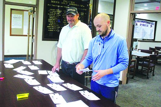 Palatka Municipal Golf Club pro Andy Heartz (left) watches as pro shop manager Austin Jacobs arranges the cards on Friday for the reboot of Day 1 of the Azalea Senior Golf Tournament today. (MARK BLUMENTHAL / Palatka Daily News)