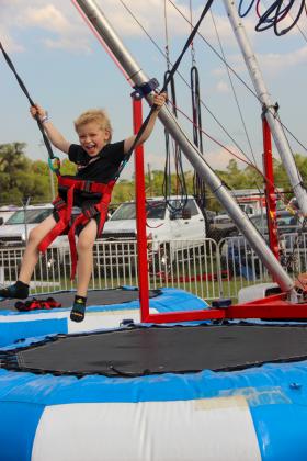Palatka child Cade Burton, 7, giggles as he gets ready to do a flip on the bungee jumping trampolines at the Putnam County Fair on Friday. (Photos by Sarah Cavacini/Palatka Daily News)