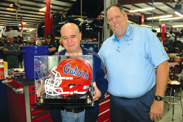 Brian Freeman, general manager of Beck Ford Lincoln, presented Buck Riggs with a framed University of Florida Gator helmet, courtesy of the staff as a farewell gift. (TRISHA MURPHY / Palatka Daily News)