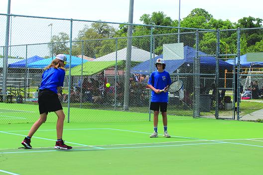 Palatka’s Wyatt Blevins hits a backhanded shot, while his brother, Mason, watches during Wednesday’s District 2-2A second doubles semifinal match against Gainesville Eastside. (MARK BLUMENTHAL / Palatka Daily News)