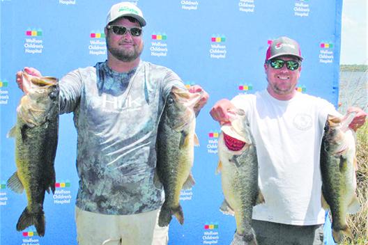 Will Scaife, left, and Branden Waters hold up some of the 30.66 pounds of bass they reeled in to win last year’s Wolfson Children’s Hospital Bass Tournament. The pair will be back to defend their championship on Saturday. (Daily News file photo)