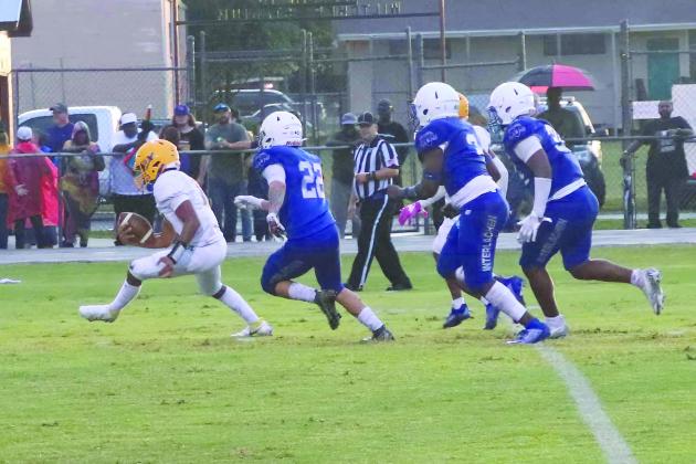 Palatka quarterback Jamarrie McKinnon tries to escape trouble with Interlachen defenders pursuing, the closest being Jonathan Servin (22). (RITA FULLERTON / Special to the Daily News)