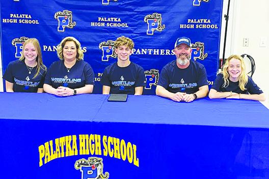 Brandon Lewis, center, smiles after signing his letter of intent to wrestle for and attended classes at Keiser University in West Palm Beach next year. Enjoying the festivities with Lewis are, from left, his girlfriend, Kaitlyn Sanders, mother Lesley Lewis, father Richie Lewis and sister Kyndal. (MARK BLUMENTHAL / Palatka Daily News)