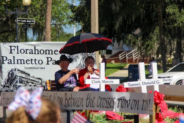 Members representing Florahome's Palmetto Park wave American flags in Monday's Memorial Day Parade in Palatka. 