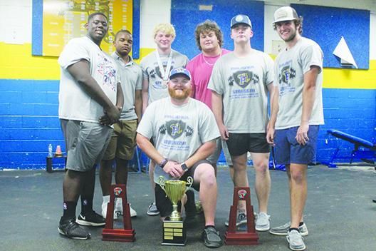 Palatka’s Dustin Whitlock (center, kneeling), who recently stepped down as the Panthers’ boys weightlifting coach, is surrounded by the trophies his team won this spring along with team members Daunte Wilkerson, Dalvin Dallas, Adaris Medina, Carson Tibbs, Luke Wilhite and Jason Purcell. (MARK BLUMENTHAL / Palatka Daily News)