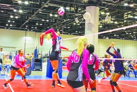 Azalea Volleyball Club player Ava Richardson (left) gets ready to spike the ball across the net during a game at AAU Nationals in Orlando. (Courtesy photos from Palatka Volleyball Facebook page)