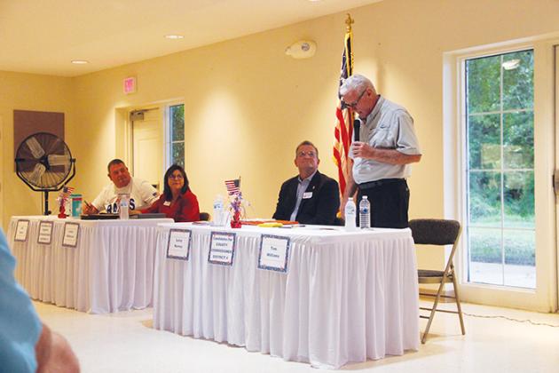Board of County Commissioners candidate Tom Williams, standing, speaks during a political forum Monday in Bostwick while other commission candidates, from left, Jeff Rawls, Leota Wilkinson and Larry Harvey listen.