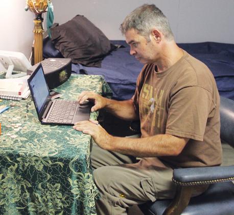 Thomas Sheppard, a graduate of the Putnam County Jail's recovery pod, works on his laptop at Recovery Point.