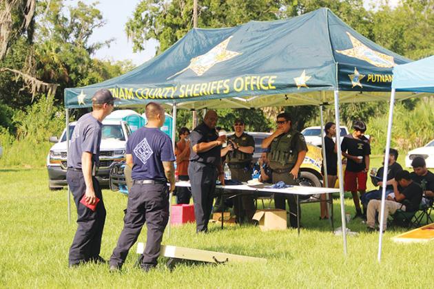 Palatka Fire Department officials face off against the Putnam County Sheriff’s Office in a game of cornhole Friday during Palatka’s Victory in the Village. 