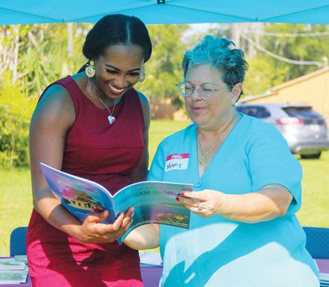 Community leader La’Farrah Davis looks at a booklet with Mary Garcia during the event.