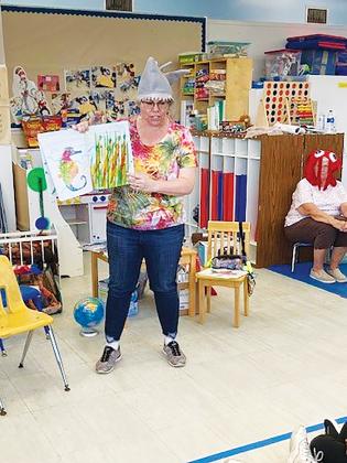 Robin Robinson, an Early Learning Coalition of North Florida volunteer, reads to children at Kidz in Action Child Care Center in Palatka.