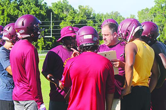 Crescent City head coach Sean Delaney (center, right), starting his third year in charge of the Raiders, goes over special teams strategy during practice this week along with assistant Keenan Henry (center, left). Below, Palatka receiver Tay Valentine goes high to make a catch against Panthers defender Jaiden Ashley in a practice the first week of the season. (MARK BLUMENTHAL / Palatka Daily News)