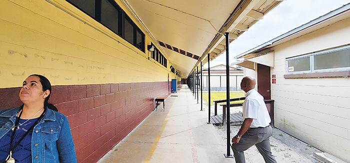 Thomas Bolling, right, assistant superintendent for support services, examines areas of Middleton-Burney Elementary School that are in need of repairs.