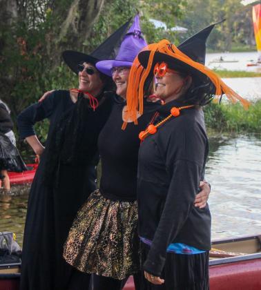 Three witches pose for photos at the Melrose Boat Ramp before paddling onto Lake Santa Fe during the 2022 Melrose Bay Witches Paddles on Friday. 