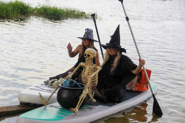 Two women decked out as witches and riding on decorate paddle boards stop for a photo Friday before heading onto Lake Santa Fe. 