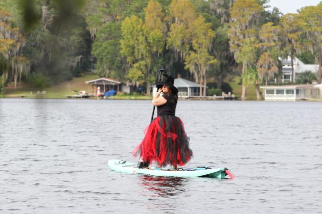 Keystone Heights woman Bonny Ivey glides across Lake Santa Fe during this year's Melrose Bay Witches Paddle on her paddleboard Friday. 
