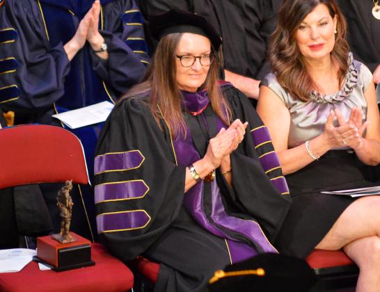Melissa Miller, center, who will be retiring from the college after three decades and was bestowed with emeritus status, is seen clapping for graduates at the 2022 Fall Commencement ceremony Thursday. (CASMIRA HARRISON/Palatka Daily News)