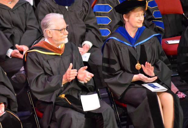 Dean of Florida School of the Arts Alain Hentschel, left, is seen clapping for graduates at the fall commencement Thursday in Orange Park. Hentschel was bestowed with emeritus status for his 13 years of service in shaping the next generation of artists. (CASMIRA HARRISON/Palatka Daily News)