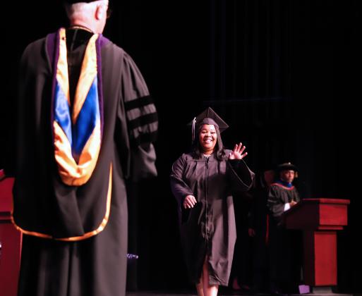 Na’Teria Hamilton walks across the stage at St. Johns River State College Thrasher-Horne Center to receive her diploma from college President Joe Pickens, left. (Susan Kessler/St. Johns River State College)