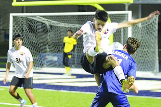 Crescent City’s Jeremiah Carbajal is upended by Holy Trinity Episcopal’s Reef Lagala early in the second half of Saturday night’s game. (MARK BLUMENTHAL / Palatka Daily News)