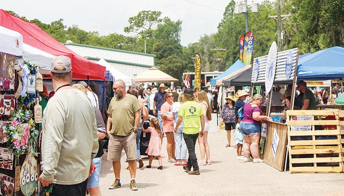 SARAH CAVACINI/Palatka Daily News Blueberry Festival attendees walk around the Bostwick Community Center grounds as they shop at vendor tents.