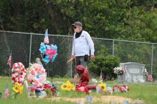 A Hollister resident searches out another veteran's gravesite Monday morning at Pineview Cemetery in Interlachen. The event is the first of several such gatherings set for this week across Putnam County. (CASMIRA HARRISON/Palatka Daily News)