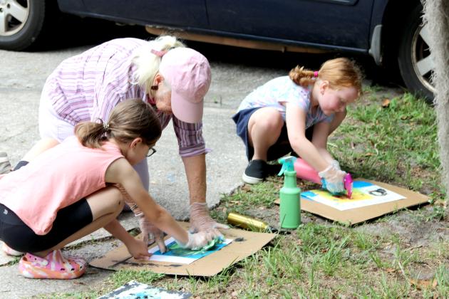 Volunteer Jane Privee helps campers with their Street Art project during the Palatka Art League Kids Summer Art Program camp on Wednesday at the historic Tilghman House in Palatka.