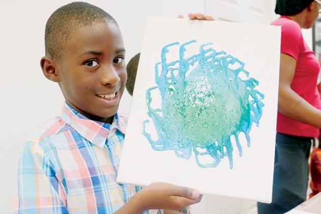 Cameron Leonard, 8, shows off his finished projects during last week’s painting class.