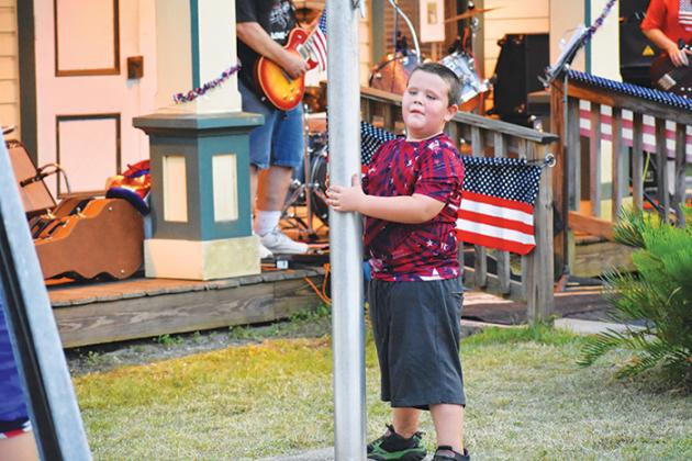 Justin Smoot Jr. plays at the flagpole in downtown Interlachen during the town’s Fourth of July festivities.