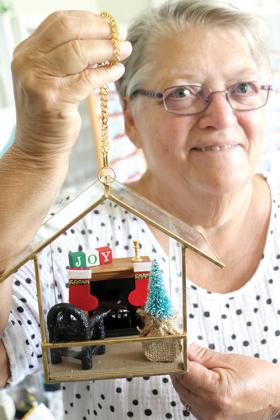 Gail Powers shows one of the miniature gardens with a Christmas theme she made that will be showcased in the Palatka Art League’s Christmas in July sale, which will begin Friday.
