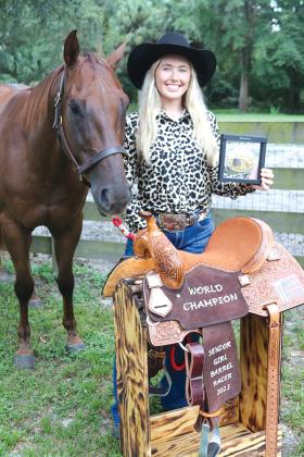 TRISHA MURPHY/Palatka Daily News -- Shaeley Jenkins stands with her horse, Dash, as she shows the belt buckle and leather saddle she won at the National Little Britches Rodeo Association finals in Guthrie, Oklahoma.