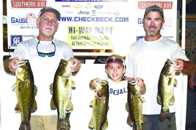 From left, Brett Bollinger, Justin Atkinson,Jr., and Justin Atkinson hold up their winning fish from last Thursday’s Corky Bell Evening Bass Tournament. (GREG WALKER / Daily News correspondent)