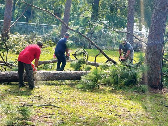 Photo courtesy of the Putnam County School District – Putnam County School District maintenance workers help remove fallen trees Friday as they help Dixie County recover from Hurricane Idalia.
