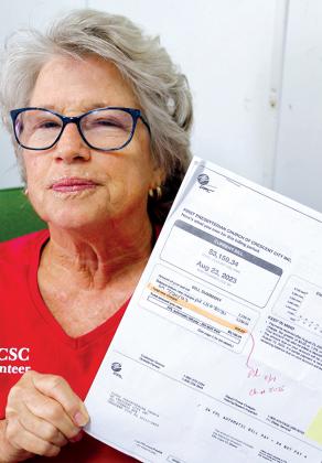 TRISHA MURPHY/Palatka Daily News – Kitty Miller, the board president for the South Putnam Christian Service Center, holds a copy of a Florida Power & Light bill that exceeds $3,000.