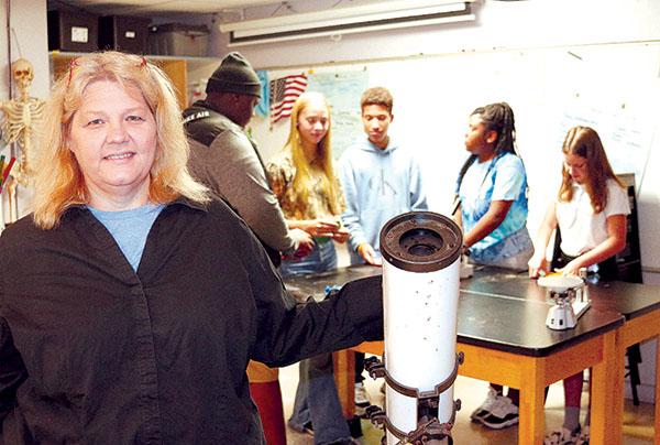 TRISHA MURPHY/Palatka Daily News Former Putnam Academy of Arts and Sciences teacher Christina Griffis stands next to a telescope while some of her students work on a project.