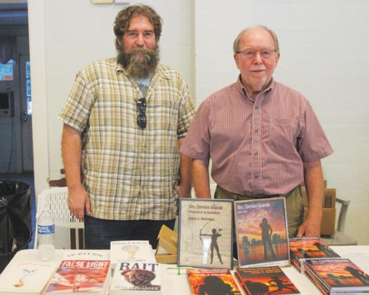 SARAH CAVACINI/Palatka Daily News – Father and son Seth Alexander and James McGregor stand at a table with their respective books during Putnam Writes!